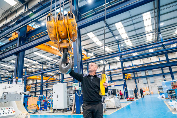 istock Worker using an industrial crane in a logistics factory 1901969943