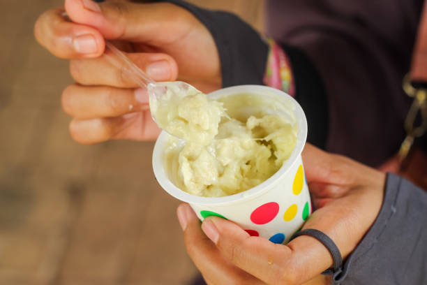 istock hand holding durian ice cream with spoon. Durian ice cream in a cup 1901974767