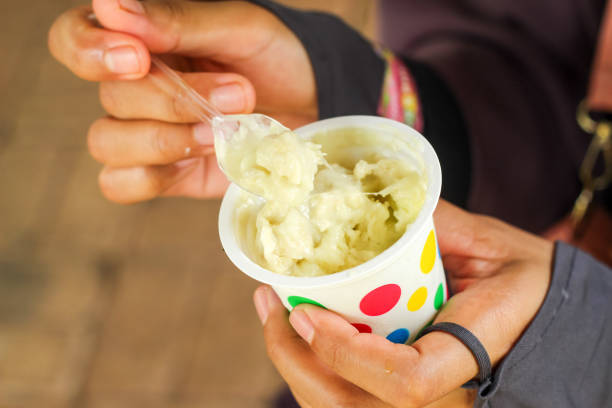 istock hand holding durian ice cream with spoon. Durian ice cream in a cup 1901974780