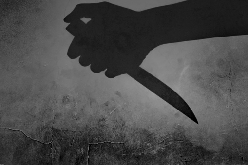 the shadow of a hand holding a knife in the darkness