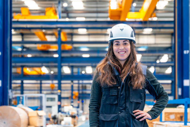 istock Smiling woman with protective gear standing in a logistic center 1902016989