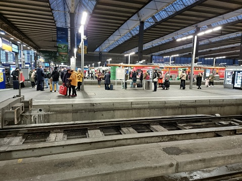 The Hague, The Netherlands - January 15, 2020: Commuters waiting on trains and trams on a two level station platform inside the central station in The Hague, The Netherlands