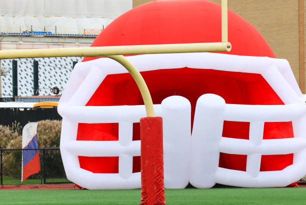 A red and white inflatable football helmet on a field.