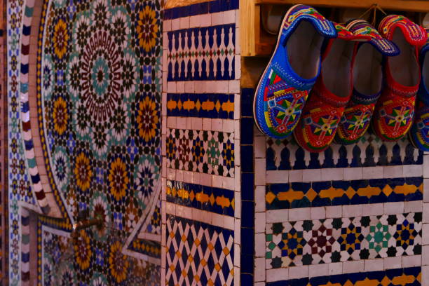 Slippers hanging on mosaic tiles, Fez souks, Morocco