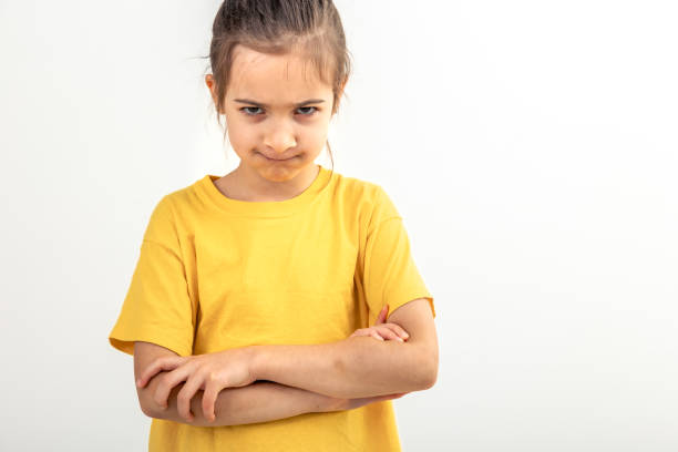 istock Angry little girl with folded hands on a white background isolated. 1902048287