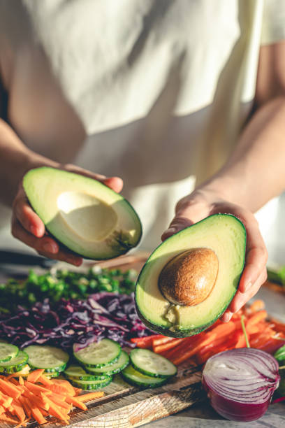 istock Close-up of a cut avocado in a woman's hands. 1902059313