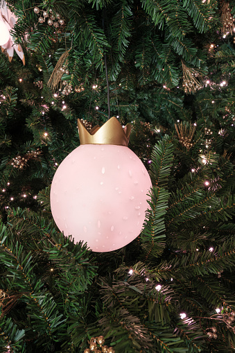 Close-up on a large pink light decoration on a Christmas tree.