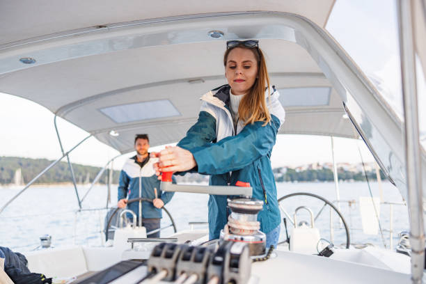 istock Blonde Woman Winding Rope Manually With Winch On Sailboat 1902109595