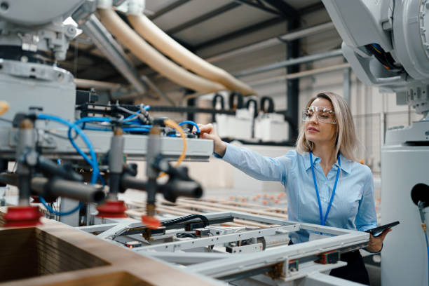 istock Female engineer in modern industrial factory, checking robotic arm, controling process and manufacturing equipment or machinery. Manufacturing facility with robotics and automation. 1902111215
