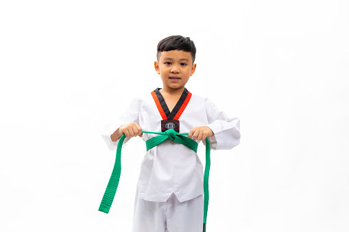 Portrait kids karate martial arts. Taekwondo uniform with green belt. Portrait Thai Asian school boy isolated on white background banner. Action sport training concept