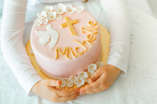 en las manos de una niña hay una tarta de cumpleaños, una tarta de primera comunión, una tarta de bautizo con hermosas flores, una paloma y una cruz, tradiciones en la fe cristiana, religión, religioso. pastel - pastel de primera comunión fotografías e imágenes de stock