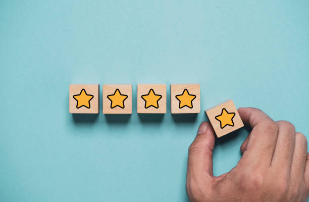 istock Client excellent sure from customer satisfaction after use product service concept , Hand holding and put yellow star to five stars which print screen on wooden cube block. 1902266089