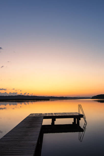 istock Bathing jetty at the lake Schaalsee during sunrise in Seedorf, Germany 1902272786