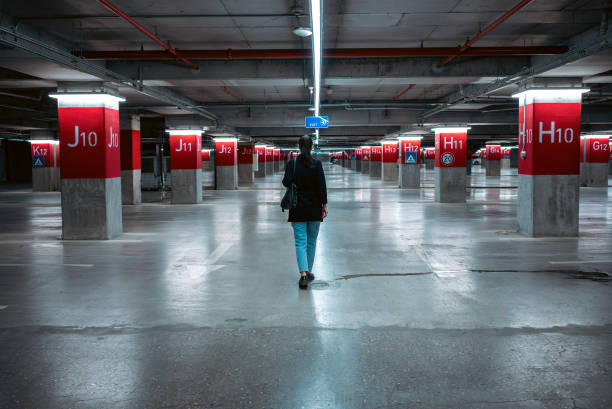 A woman walks alone  in a deserted parking lot