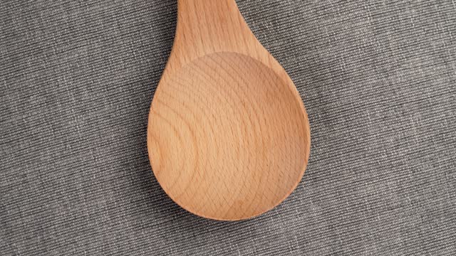 Eco friendly wooden spoon on rough rustic cloth. Clean ecological product. Rotation