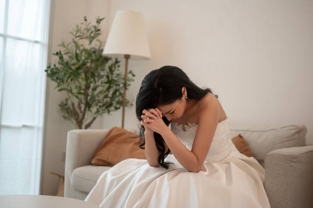 Sad and worried bride crying and arguing with groom in wedding day stock photo