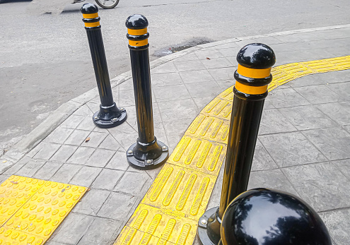 black poles dividing the sidewalk. selective focus