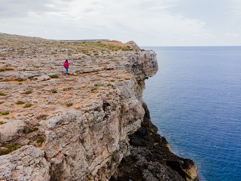 Malta. View from above. A tourist walks along a cliff.