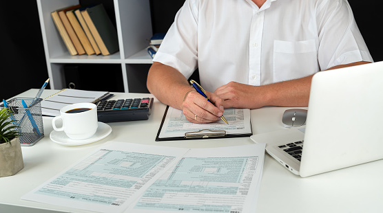 man completing tax form 1040. Tax time, accounting concept