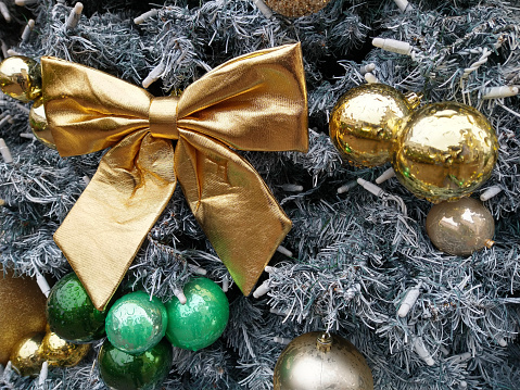 Modern Christmas tree decorations with colored balls and gold bow