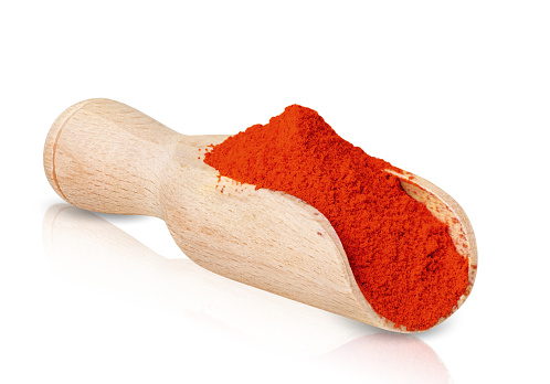 Chili pepper seasoning isolated on white background. Dry ground chilli powder in wood spoon