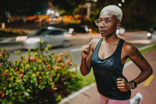 istock A young woman exercising at night running 1902357781