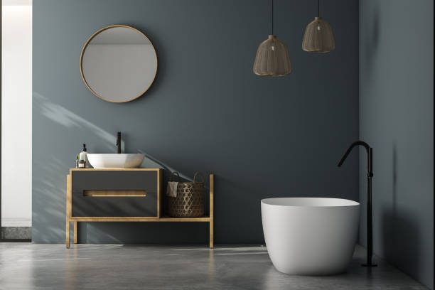 istock Modern minimalist bathroom interior, modern bathroom cabinet, white sink, wooden vanity, interior plants, bathroom accessories, bathtub and shower, white and blue walls, concrete floor. 1902357989