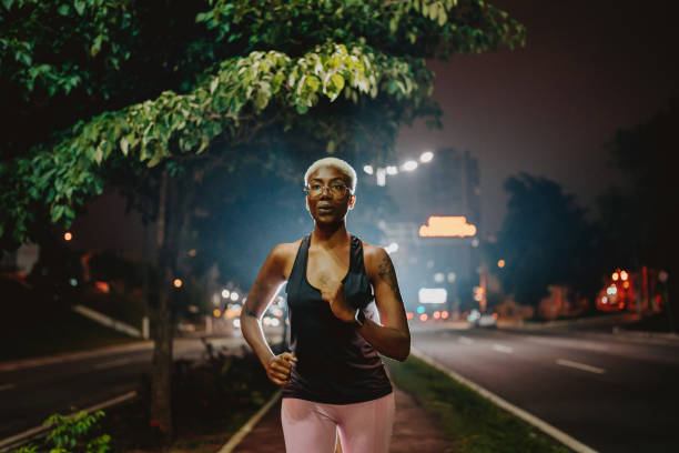 istock A young woman exercising at night running 1902359528