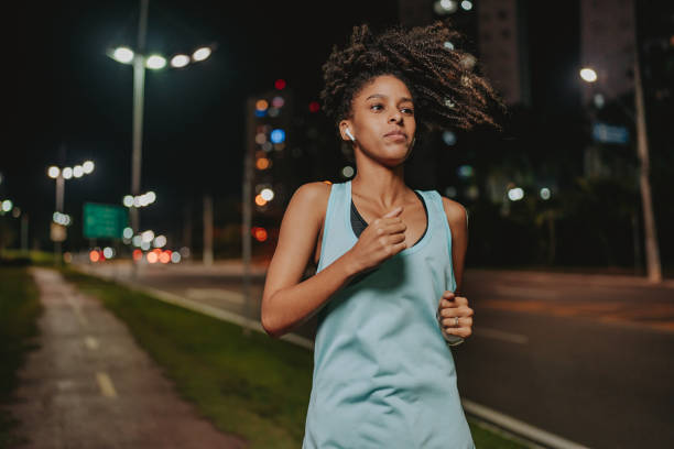 istock A young woman exercising at night running 1902359712