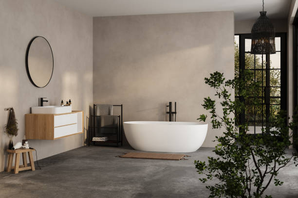 istock Modern minimalist bathroom interior, modern bathroom cabinet, white sink, wooden vanity, interior plants, bathroom accessories, bathtub and shower, white and beige walls, concrete floor. 1902389945