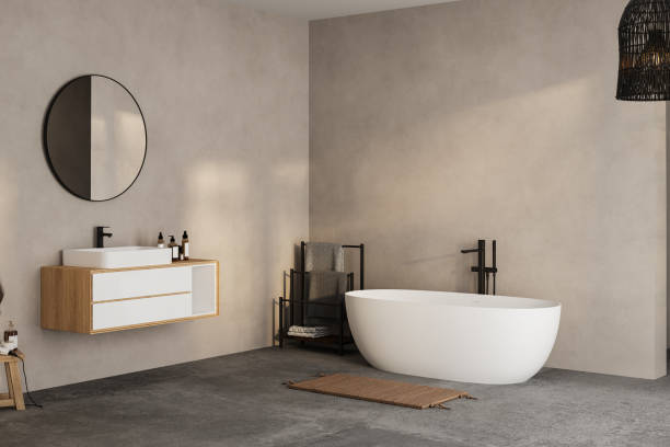 istock Modern minimalist bathroom interior, modern bathroom cabinet, white sink, wooden vanity, interior plants, bathroom accessories, bathtub and shower, white and beige walls, concrete floor. 1902398661