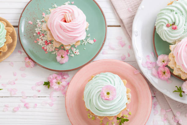 istock pink and green cupcakes with spring flowers on white wooden background 1902448596