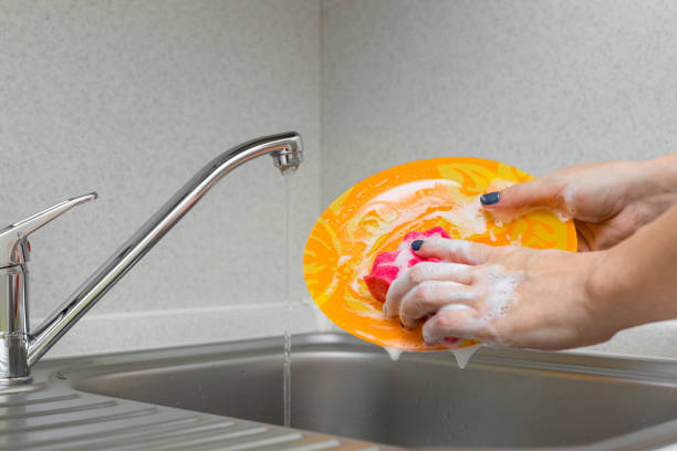 istock woman in the kitchen washing dishes with a sponge 1902509245