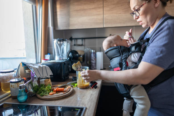 istock Busy tired mum feeding her baby 1902539699