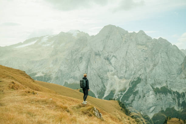 istock Young woman hikes up path in mountains 1902621757
