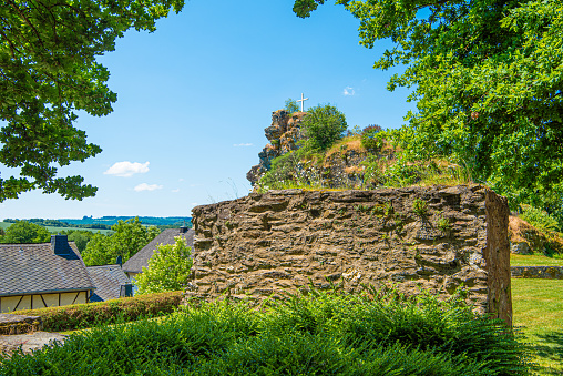 Blick auf eine Mauer der zerstörten Burg in Hunolstein bei Morbach im Hunsrück an einem Sommertag