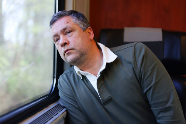 istock Sad man looking out the window into the train. 1902689062