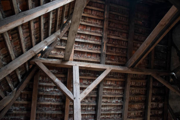 Old ruined attic with attic and visible roof tiles.