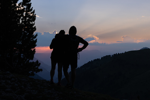 Couple hiking outdoors on the Dolomites, enjoying sunset