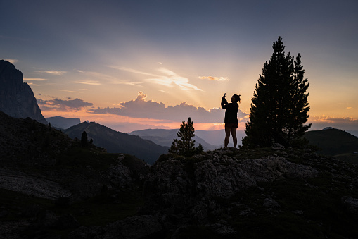 Woman hiking outdoors on the Dolomites, enjoying sunset