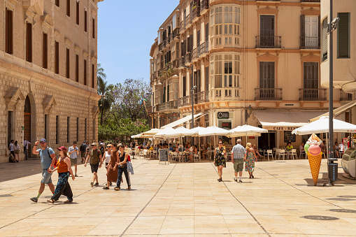 Málaga, Spain, June 13, 2022; People walk across a pleasant square in the old historic center of the city of Málaga.