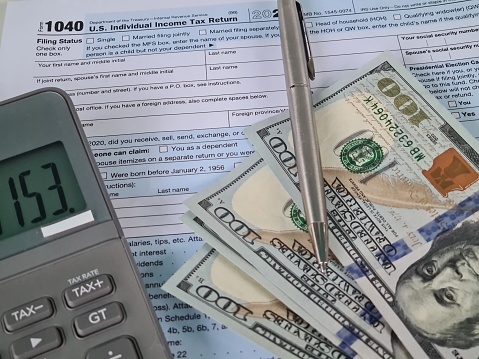 US tax form 1040 with dollars and calculator. Tax refund calculation