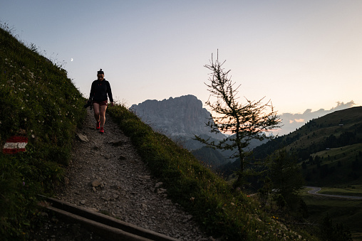 Woman hiking outdoors on the Dolomites in summer, around Passo Gardena, between Val Badia and Val Gardena