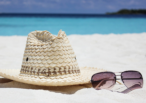 Straw Hat and Sun Glasses on a Paradise Tropical Beach. Travel tourism background concept.
