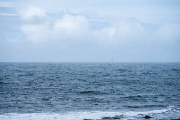 istock Sailboat barely visible in bad weather at sea.. 1902824387