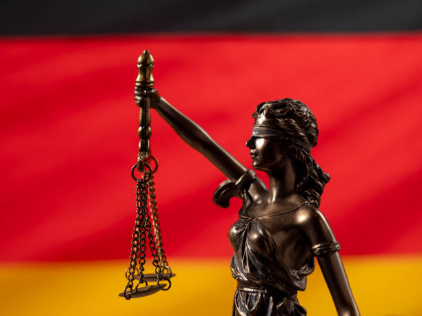 Bronze statue of justice with the German flag in the background. Bronze statue of justice with the German flag in the background. German law concept. civil rights act stock pictures, royalty-free photos & images