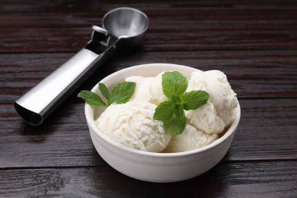 istock Delicious vanilla ice cream, mint and scoop on wooden table 1902939082