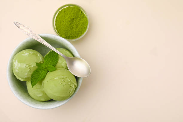 istock Tasty matcha ice cream, spoon and powder on beige table, flat lay. Space for text 1902943323