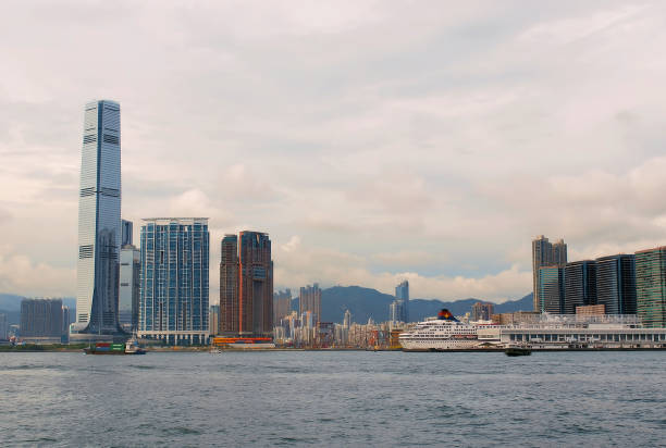 West Kowloon, Hong Kong This photograph shows a portion of an area in Hong Kong known as West Kowloon. Towards the left side stands a famous skyscraper known as the International Commerce Centre (ICC), and on the right side, is what appears to be a cruise ship for tourists. The scene was photographed during September of 2010. international commerce center stock pictures, royalty-free photos & images