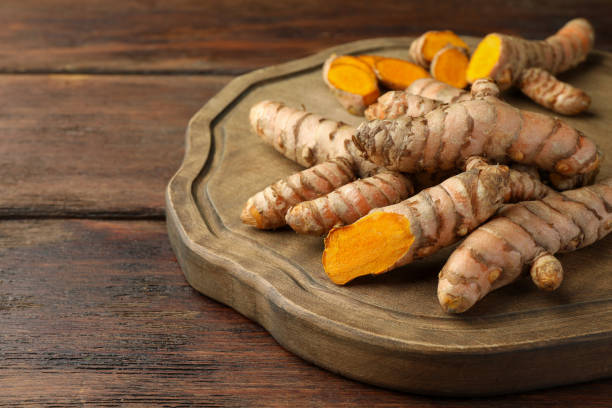 istock Many fresh turmeric roots on wooden table, closeup. Space for text 1902972013